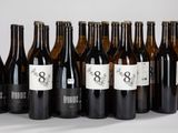 six bouteilles de vin sont alignées sur une table