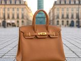 a brown leather handbag sitting on the ground in front of a building