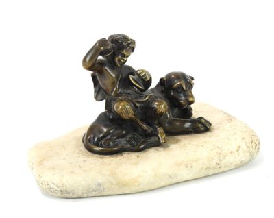 figurine en bronze représentant un garçon et un chien assis sur un rocher