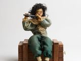 a figurine of a woman sitting on a wooden box