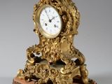 une horloge en or posée sur un bloc de marbre