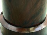 a vase with a wooden base on a white surface