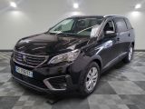 la voiture noire est garée sur un sol en damier dans le garage