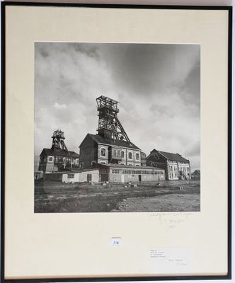 photographie en noir et blanc d'une ancienne usine avec une tour horloge en arrière-plan