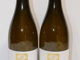 deux bouteilles de vin posées sur une table l'une à côté de l'autre
