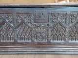 a wooden chest with carvings on it on a wooden floor