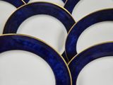 six blue and white plates with gold rims on a table