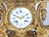 a gold clock that is sitting on top of a table