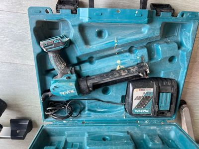 une caisse à outils bleue avec des outils sur le sol
