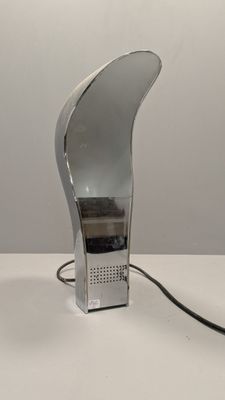 a silver lamp that is on a white table