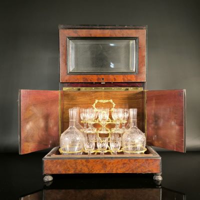 bottles and glasses in a wooden case with a mirror on a table