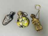 trois flacons de parfum miniatures sont posés les uns à côté des autres sur une table