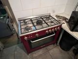 un four de cuisinière rouge installé dans une cuisine, à côté d'un évier