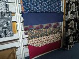 a lot of different fabrics on a rack in a room