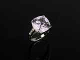 une bague en améthorate et diamant posée sur une surface noire