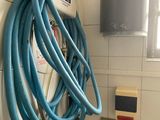 a blue hose attached to a wall in a bathroom