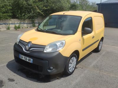 une camionnette jaune garée sur un parking avec des arbres en arrière-plan