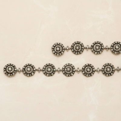 three silver bracelets with black and white stones on a white surface