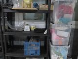 a black shelf with plastic bins on top of it