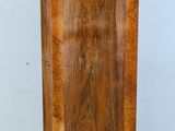 a tall wooden cabinet sitting on a tile floor