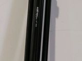 a black tripod sitting on the floor next to a white wall