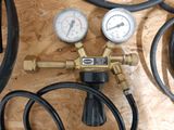 two gauges and a couple of hoses sitting on a table