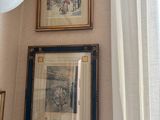 two paintings on the wall above a toilet in the bathroom