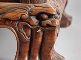close up of a wooden bench with a carved design on the back