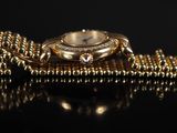 an image of a close up of a watch on a chain