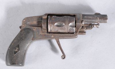 an old gun that is sitting on a white surface