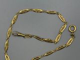 gros plan d'un collier en or sur une surface grise