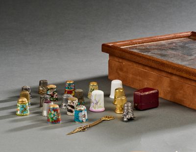 une boîte en bois contenant un tas de dés à coudre et une paire de ciseaux