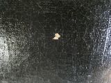 un morceau de tissu noir sur lequel se trouve un petit morceau de tissu jaune