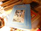 un livre bleu posé au sommet d'une pile de livres