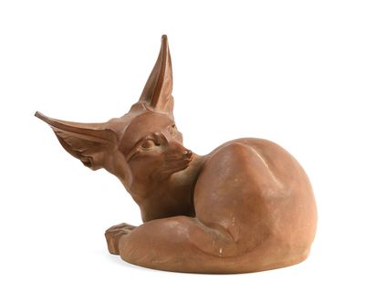 une sculpture en argile représentant un chat couché sur une surface blanche
