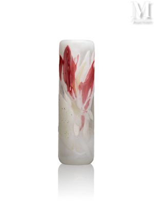 une bougie ornée d'une fleur rouge et blanche, posée sur une surface blanche