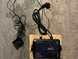 une télécommande posée par terre à côté d'un chargeur