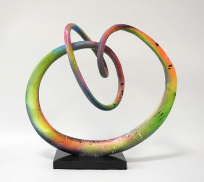 sculpture composée de spirales multicolores sur un socle noir, se détachant sur un fond blanc