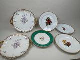 cinq assiettes ornées de fleurs posées sur une table