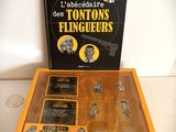 La boîte contient divers objets, notamment un pistolet, un livre et la photo d'un homme.