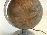 a wooden globe with a metal base on a table