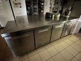 plan de travail en acier inoxydable dans une cuisine commerciale avec des casseroles et des poêles dessus