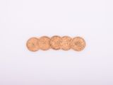 a close up of a pile of coins sitting on top of a white surface