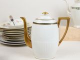 a white and gold tea pot sitting on a table