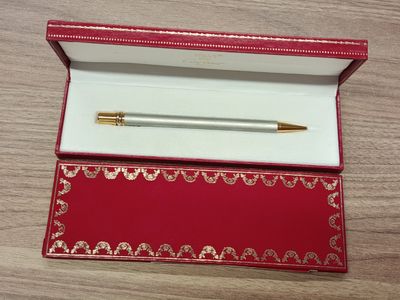 un stylo dans une boîte rouge posée sur une table en bois