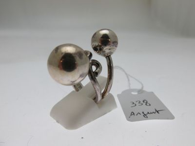 une paire de boucles d'oreilles plaquées argent posées sur un fond blanc, avec une étiquette de prix