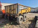 un camion-benne garé sur un terrain en terre battue