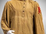 a mannequin wearing a brown shirt with red crosses on it