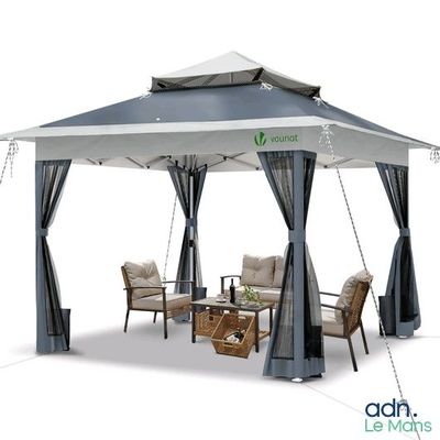 un gazebo avec des rideaux et une table entourée de chaises