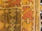 a close up of a yellow and black rug with a pattern on it